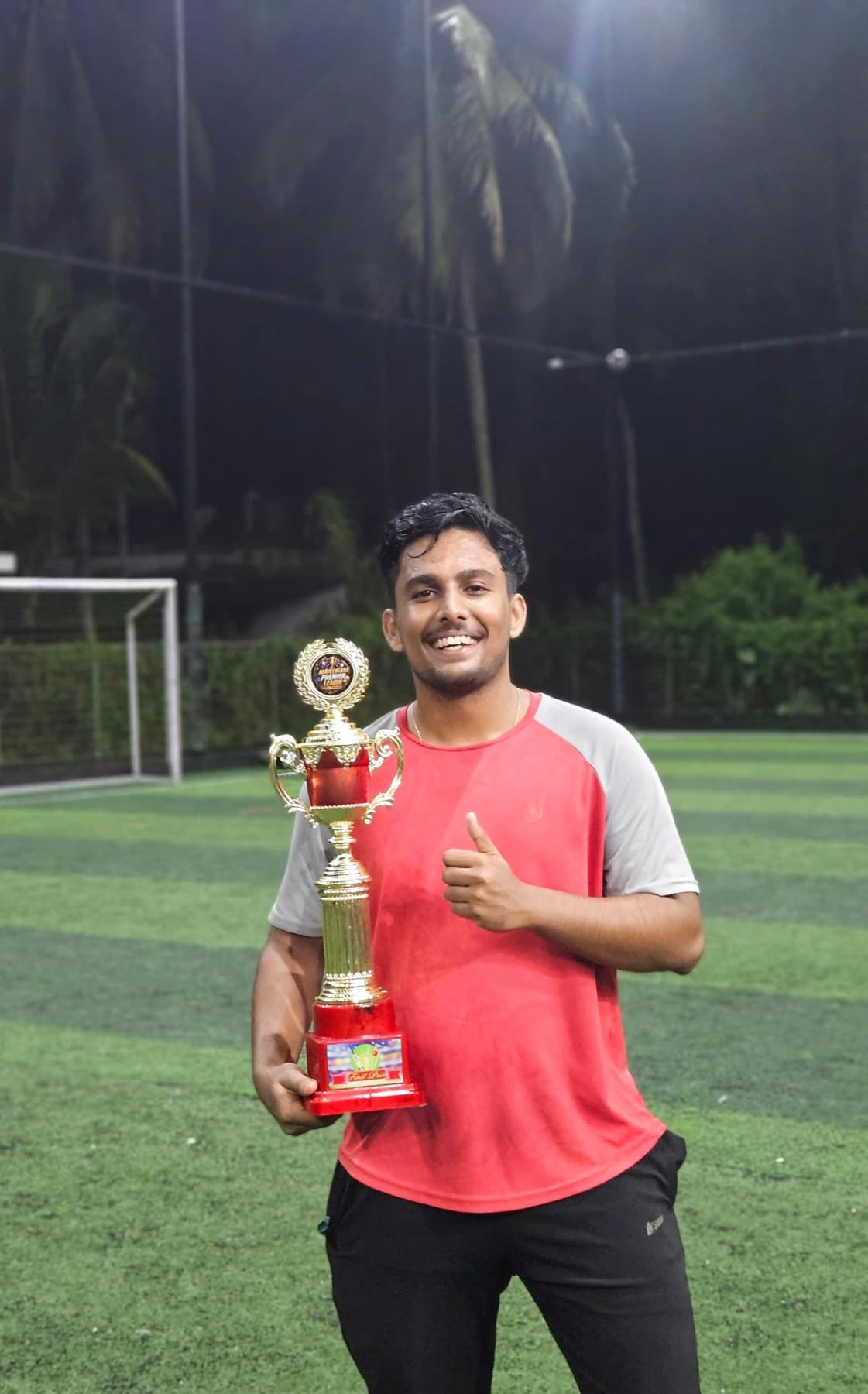 Adarsh holding a trophy